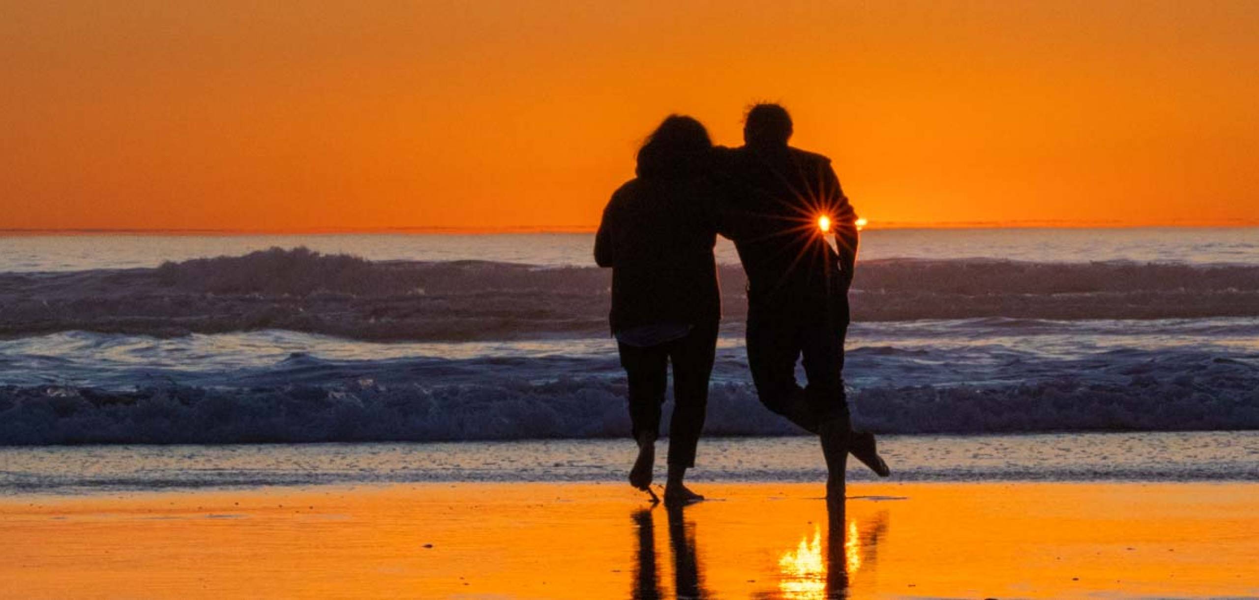 Enjoy fabulous sunsets on the Long Beach Peninsula Couple on the beach at sunset