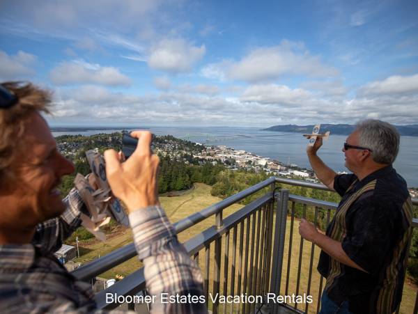 Astoria Column Photo of an adult mail throwing toy airplane off of top of astoria column
