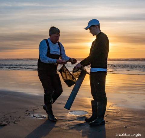 Father and son dig for razor clams