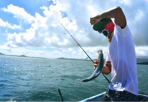 Man with trout on a boat on a lake