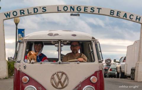 People come from all over the world to show off their vintage cars 1962 VW Bus in front of World's Longest Beach sign