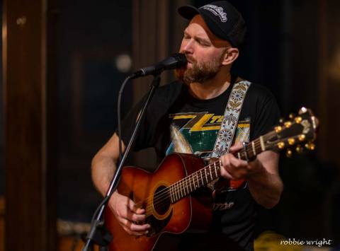 Local artists playing music at the North Beach Tavern Man singing on stage